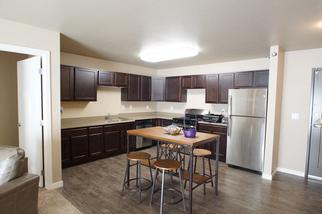 a kitchen with stainless steel appliances and a bar with three stools