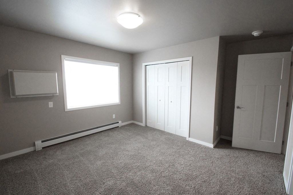 a room with carpet and a door and a window