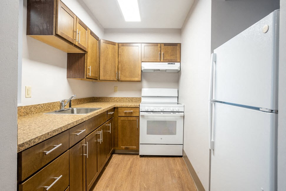 a kitchen with wooden cabinets and a white stove and refrigerator