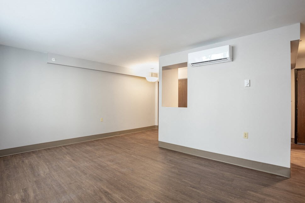 an empty living room with white walls and wood floors