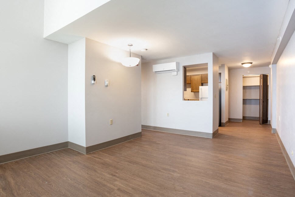 an empty living room and hallway with white walls and wood floors