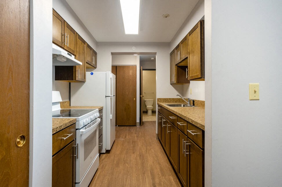 a kitchen with white appliances and wooden cabinets
