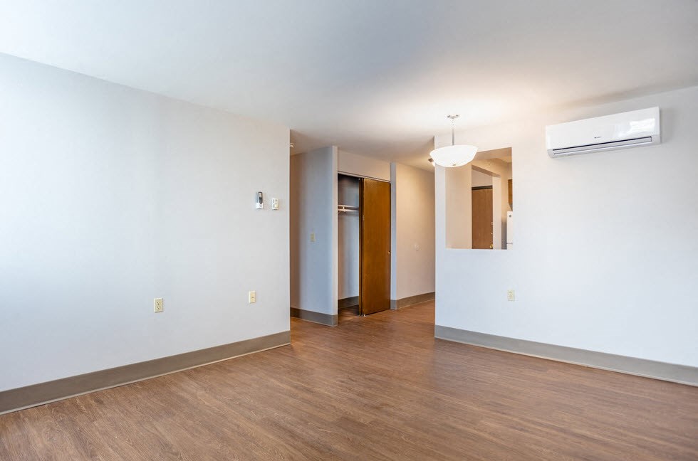 an empty living room with white walls and wood floors