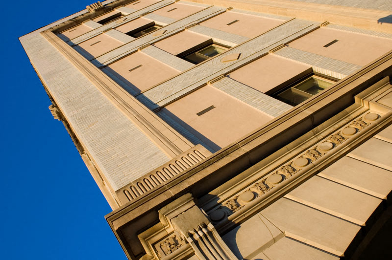 an upward view of a tall building against a blue sky