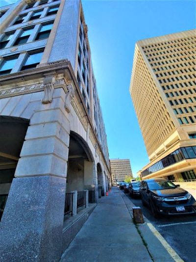 a city street with cars parked next to a tall building
