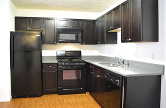 L-shaped kitchen with dark cabinets and gray countertop
