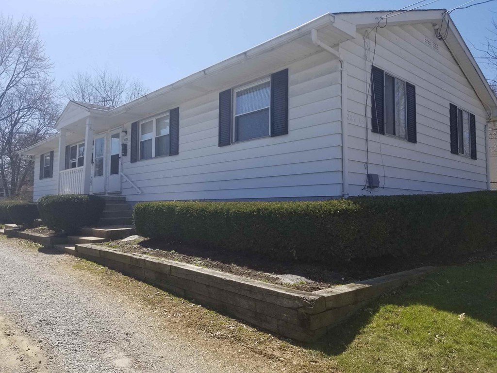 A mobile home with a white exterior and black shutters.