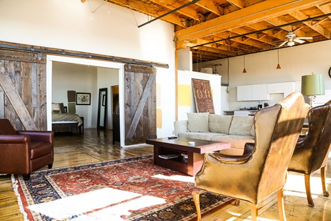 A living room with a rug and a brown chair.