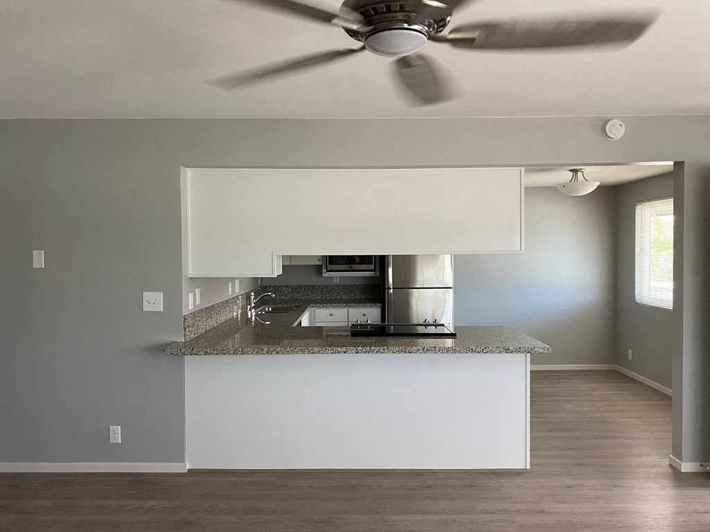 a kitchen with a counter top and a ceiling fan