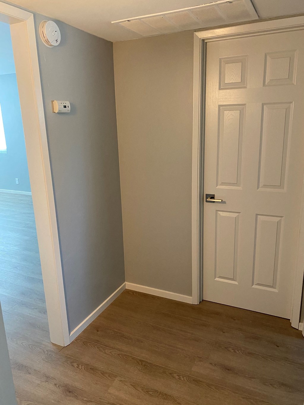 a room with a white door and a hallway with a door to a closet
