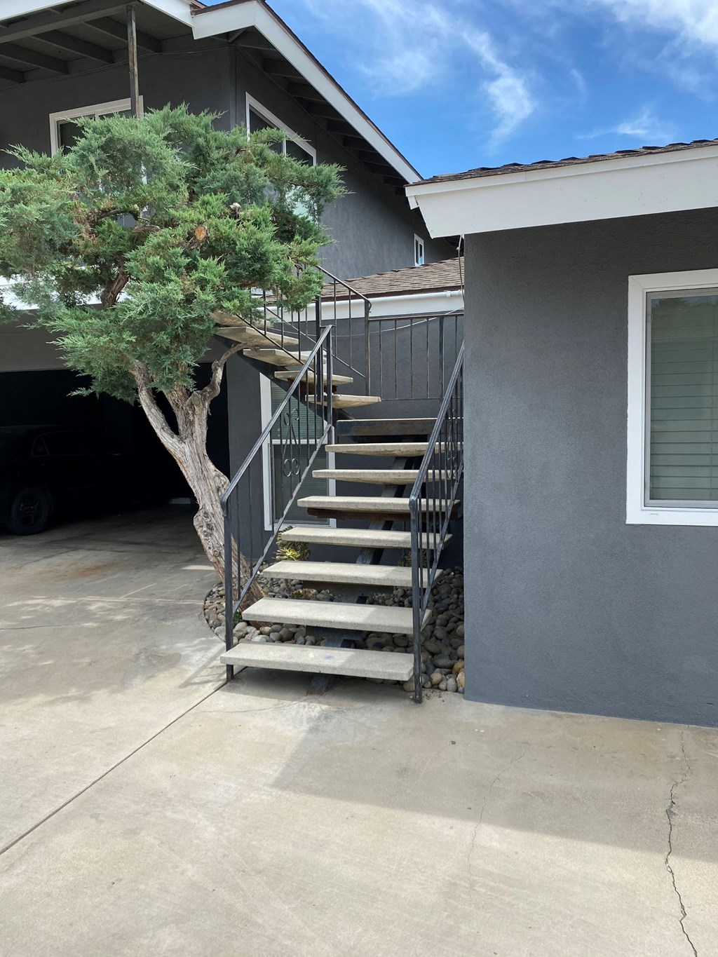 a set of stairs with a tree next to a house