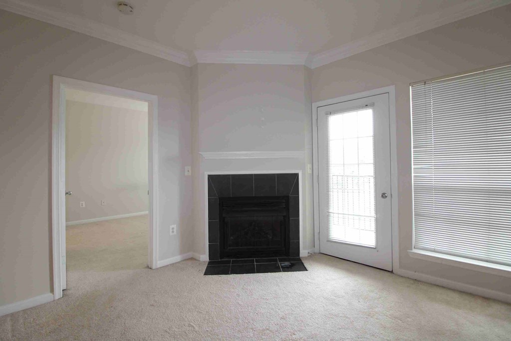 an empty living room with a fireplace and a door