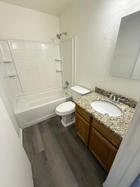 A white bathroom with a toilet, sink, and shower.