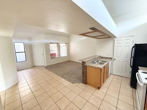 A kitchen area with a sink and a refrigerator.