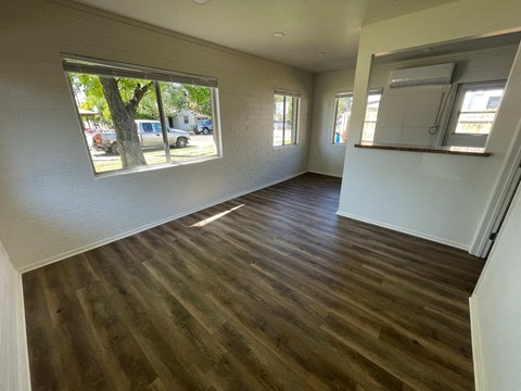 a living room with a hard wood floor and a large window