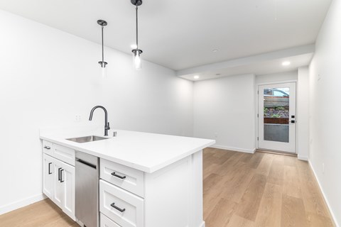 A kitchen with white cabinets and a white counter top.