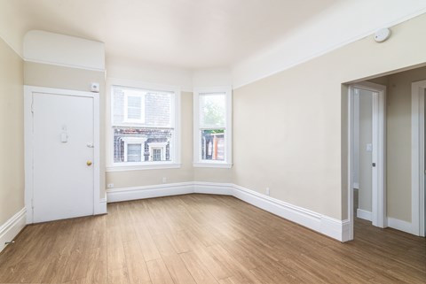 A room with a white door and a window with a view of a building outside.