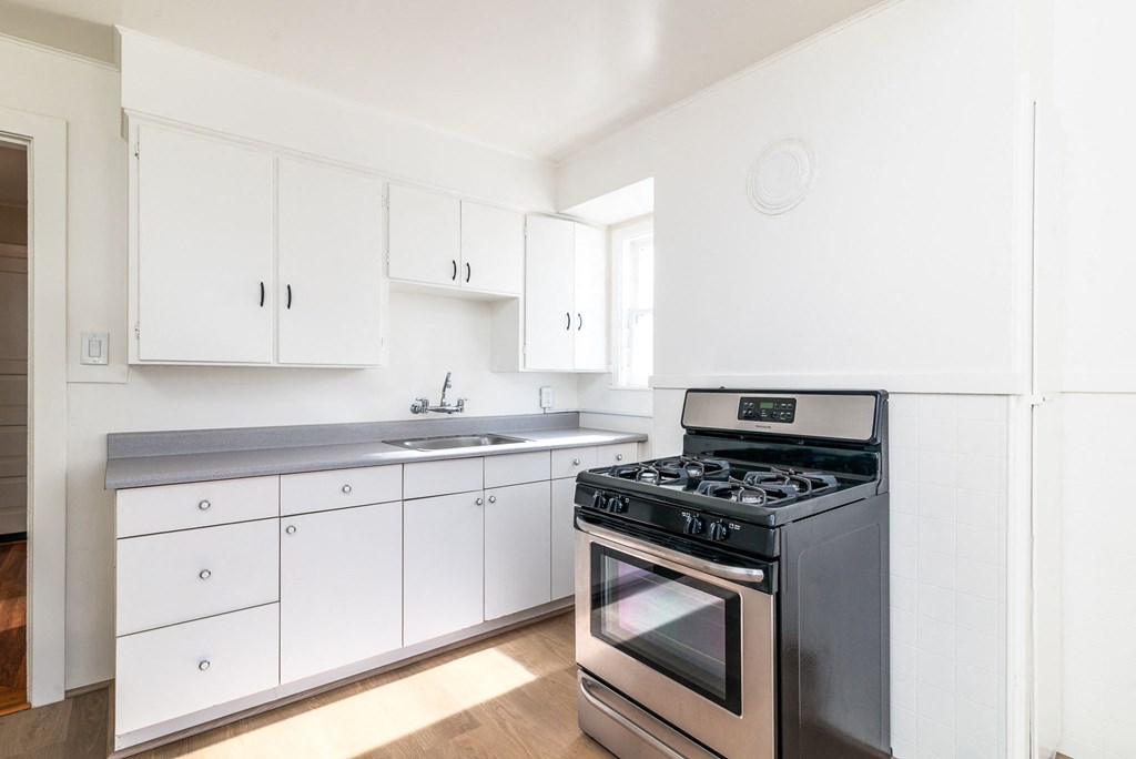 A modern kitchen with a stove and cabinets.