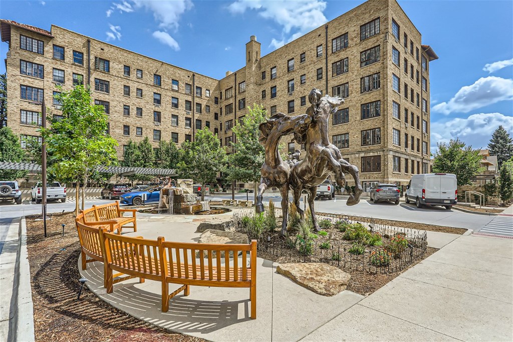 a statue of a cowboy on a horse in front of a building