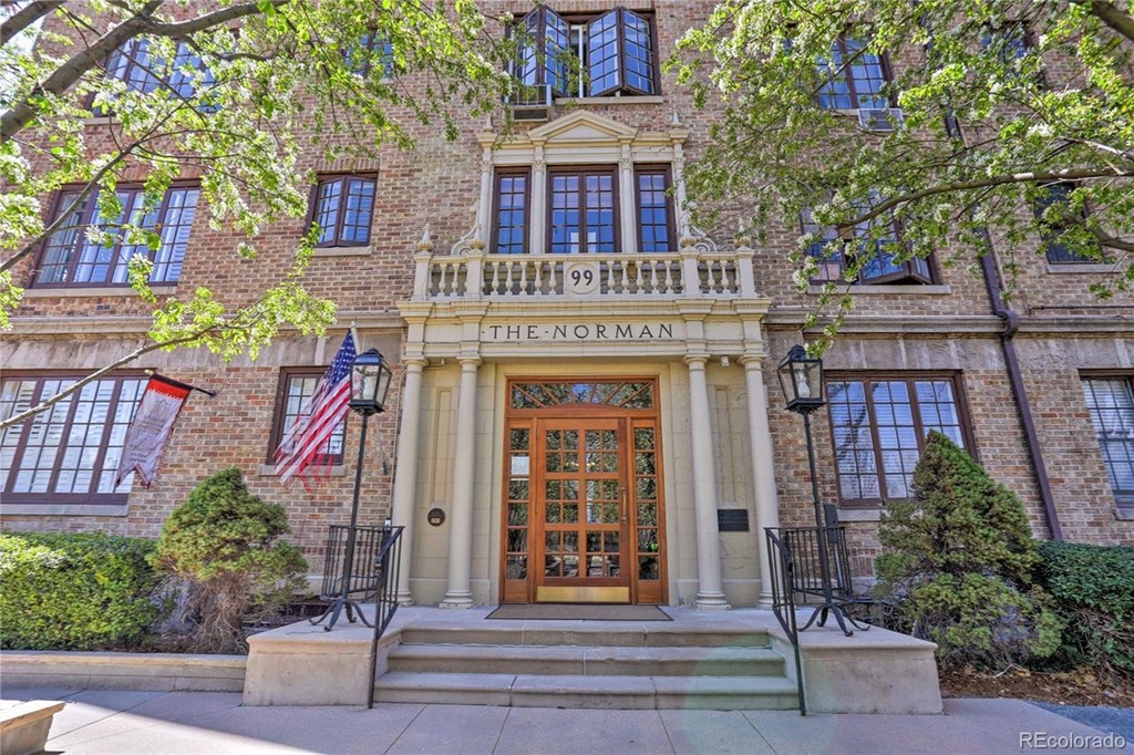 a large brick building with a brown door and stairs
