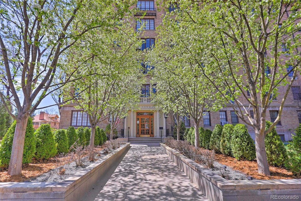 the front of a building with trees and a pathway