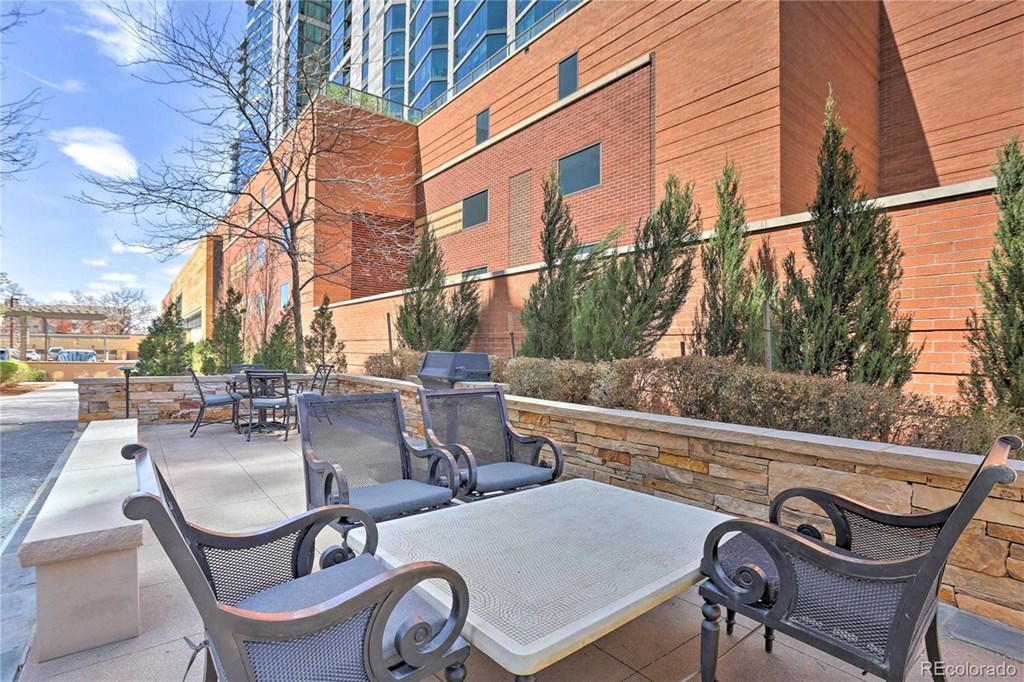 a patio with tables and chairs outside of a building