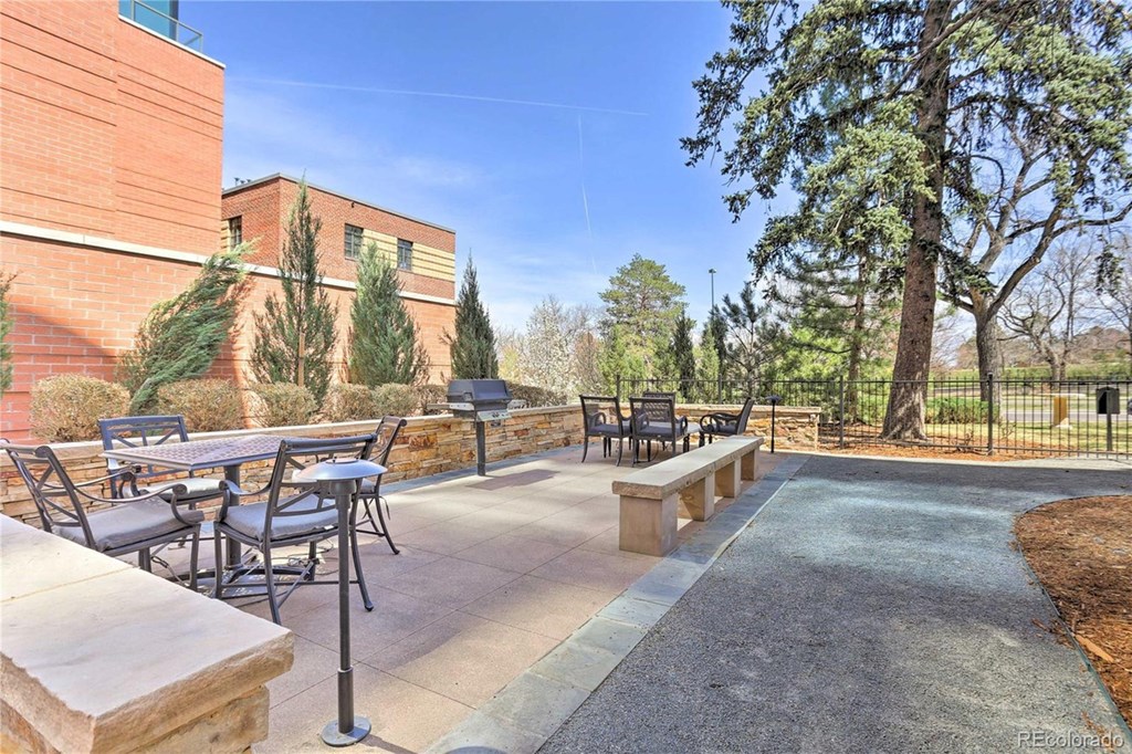 a patio with tables and chairs in front of a building