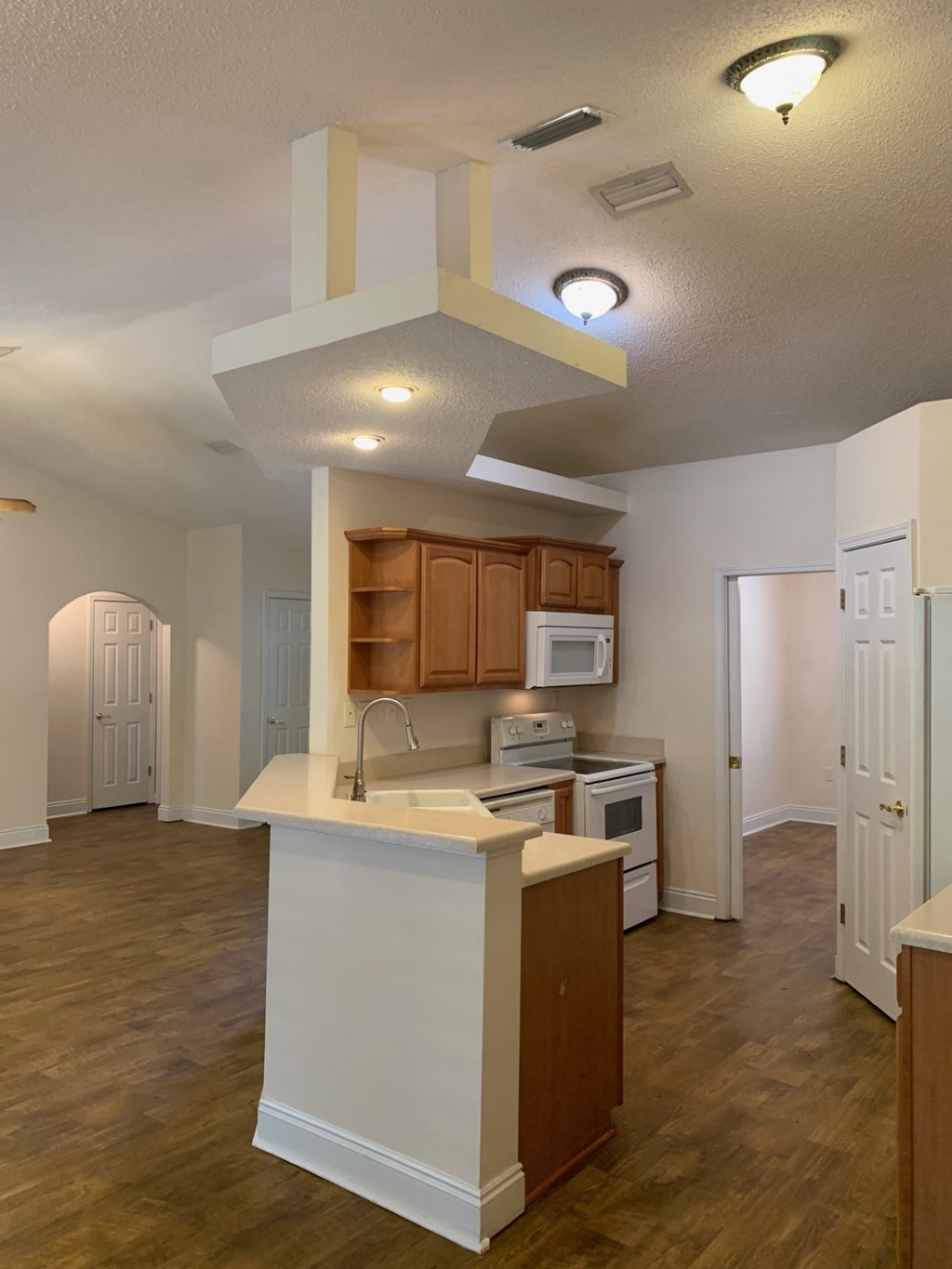 A kitchen with wooden cabinets and a white island.