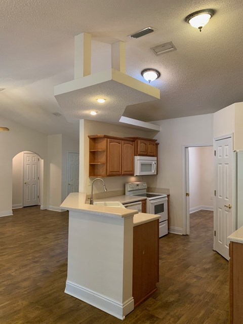 A kitchen with wooden cabinets and a white island.