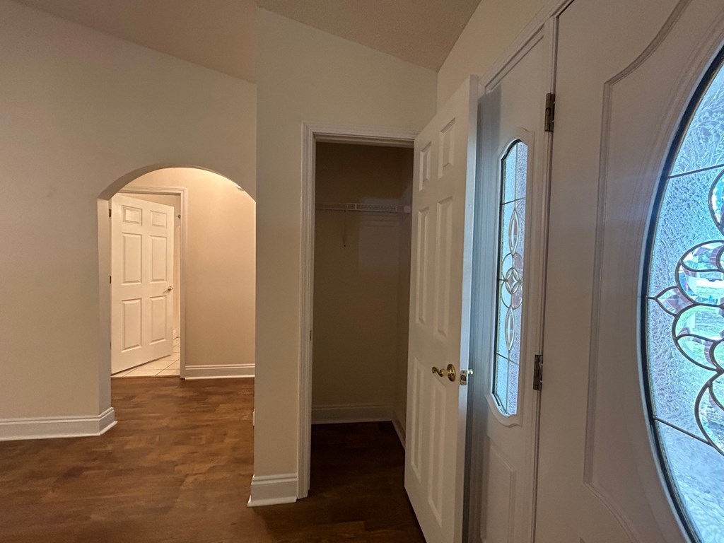 A hallway with a white door and a stained glass window.