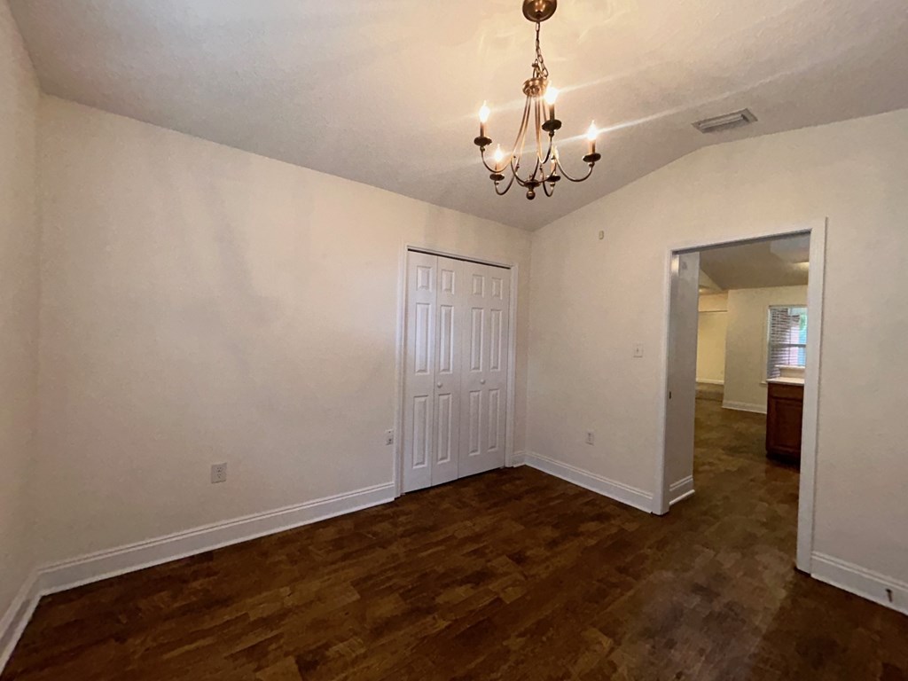 A room with a chandelier and a door.