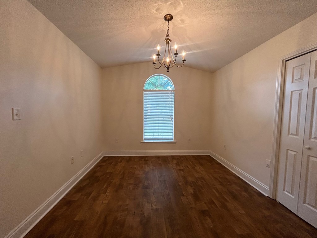 A room with wooden floors and a chandelier.