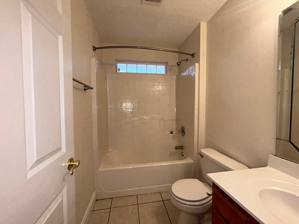 A white bathroom with a toilet, sink, and bathtub.
