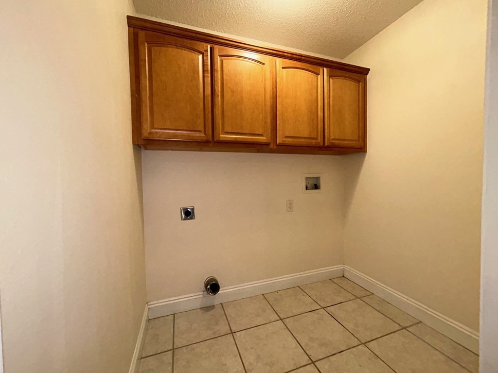 A room with a brown cabinet and tile floor.