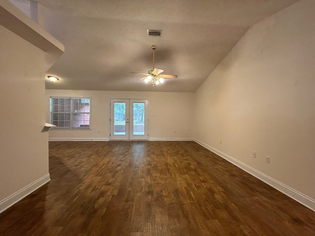 A room with wooden floors and a ceiling fan.