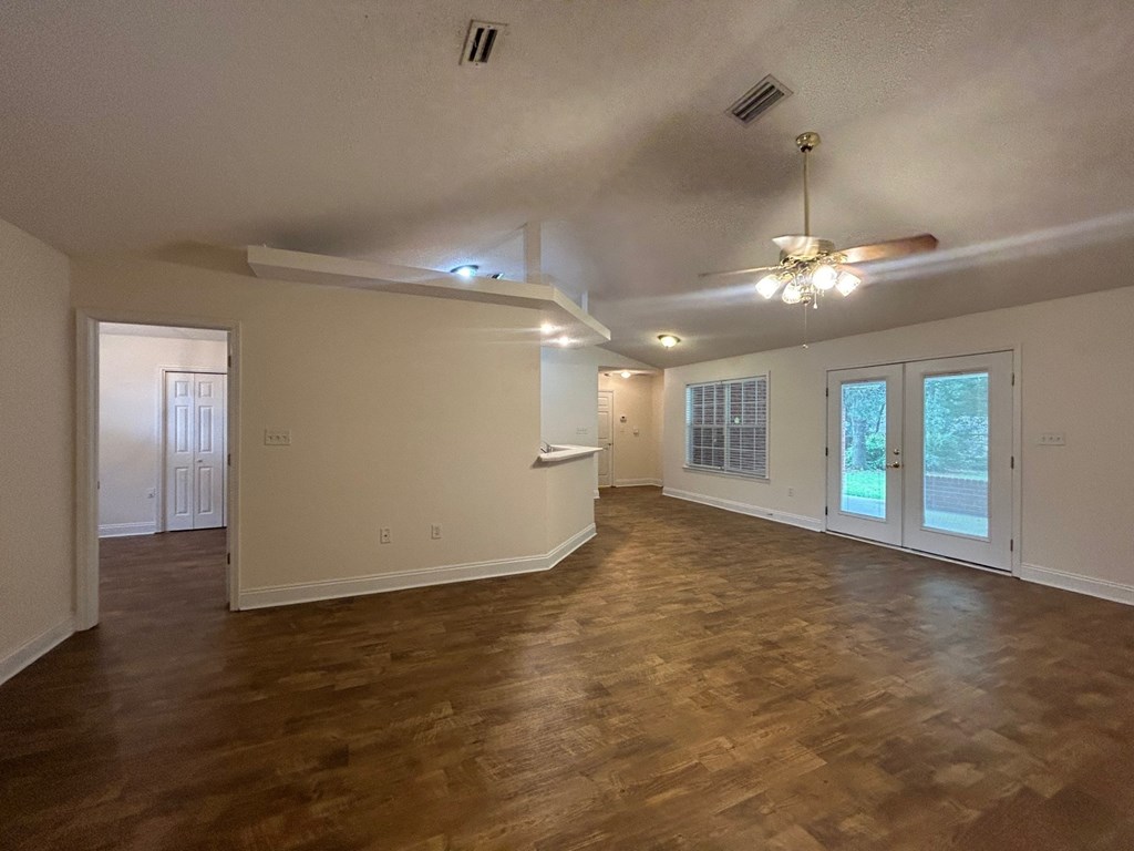 A room with wooden floors and a ceiling fan.