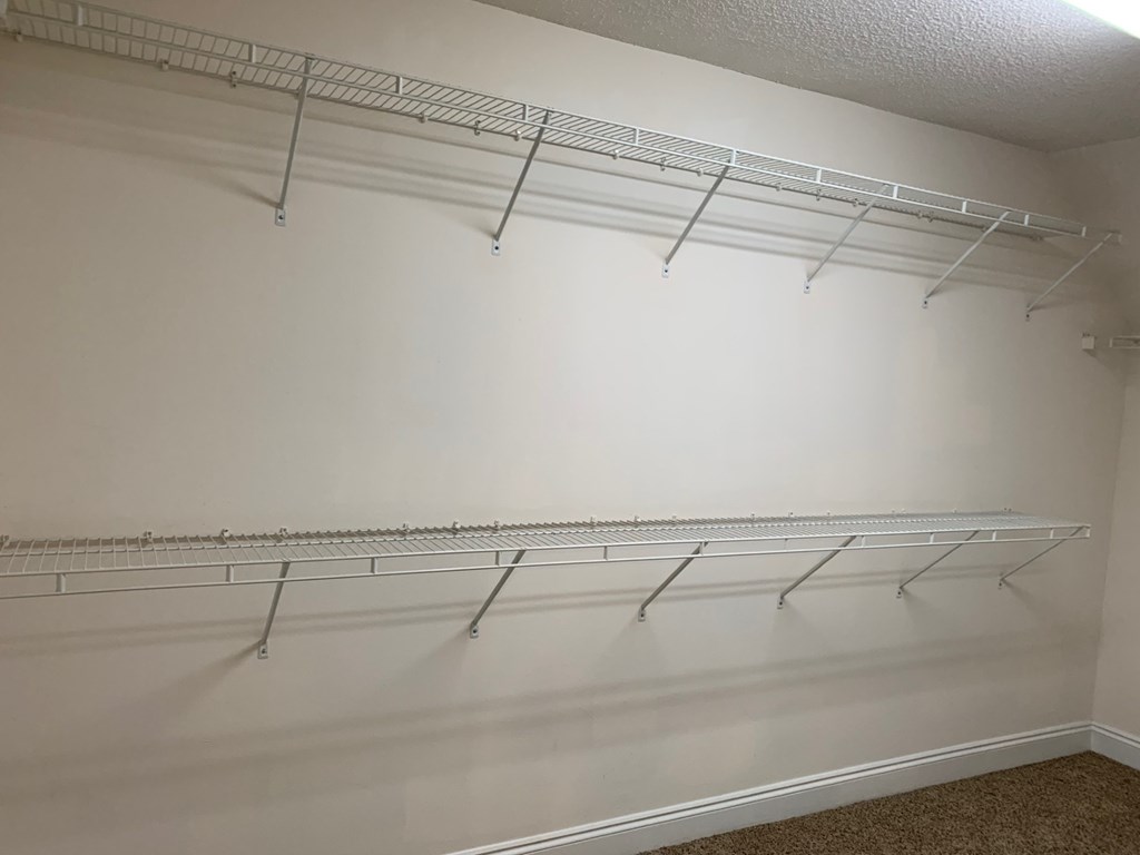 A white wall with two metal racks on it.