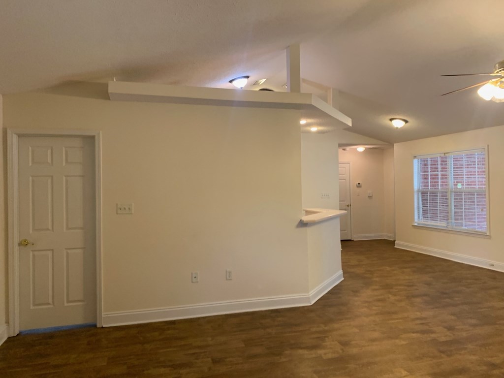 A room with a white door and a window with blinds.