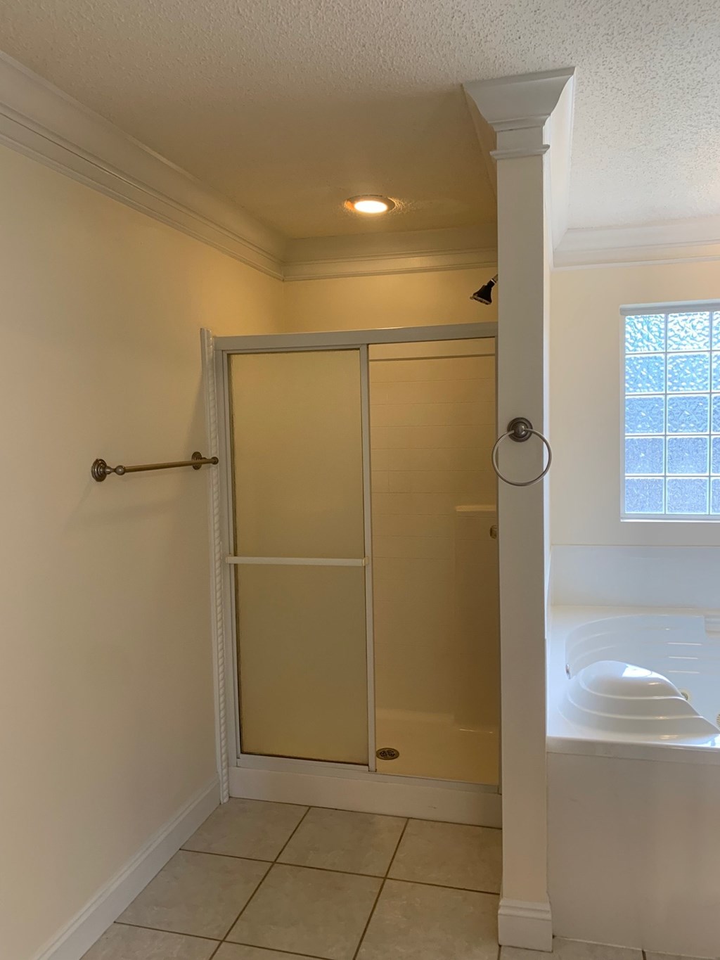 A white bathroom with a glass shower door and a white toilet.