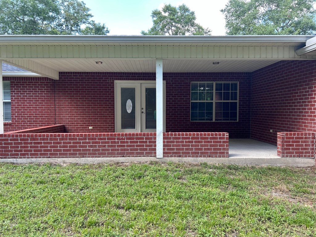 A red brick house with a white door and window.