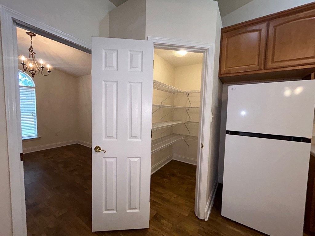 A white door is open to a small kitchen.