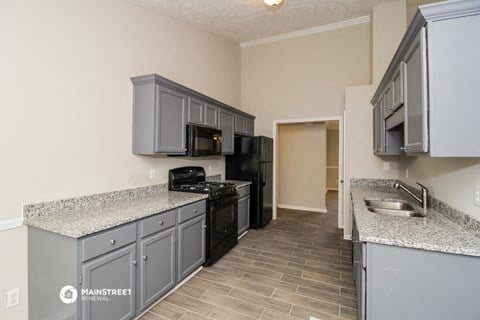 a kitchen with gray cabinets and a black stove and refrigerator
