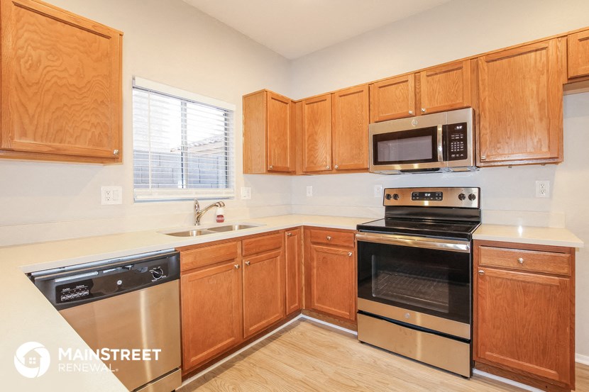 a kitchen with wooden cabinets and stainless steel appliances
