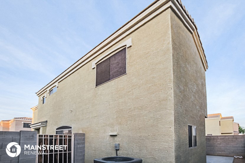 the side of a brick building with a window and a fountain