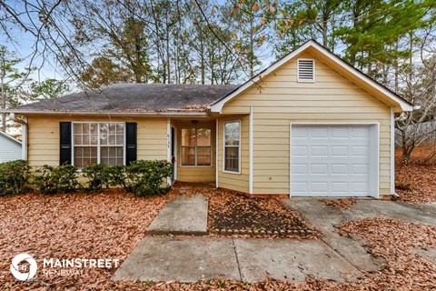 a small yellow house with a white garage door