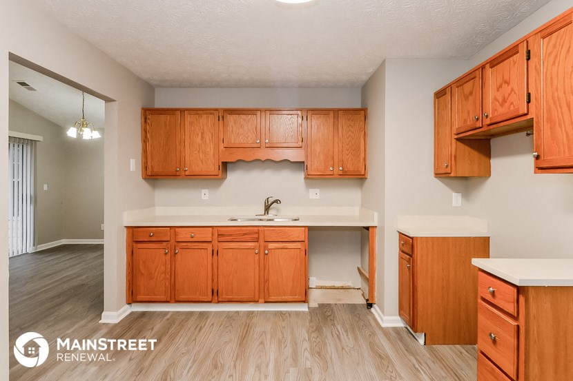 a kitchen with wooden cabinets and a sink and a counter