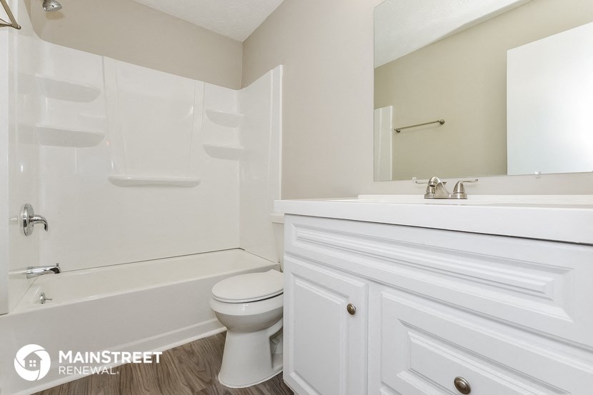 a bathroom with a toilet and a sink and a bath tub