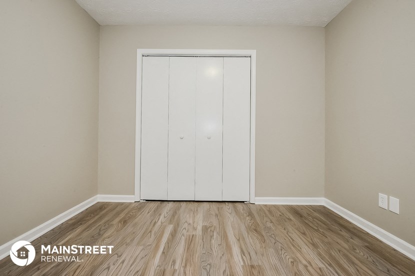 the interior of a bedroom with a closet and wooden floors