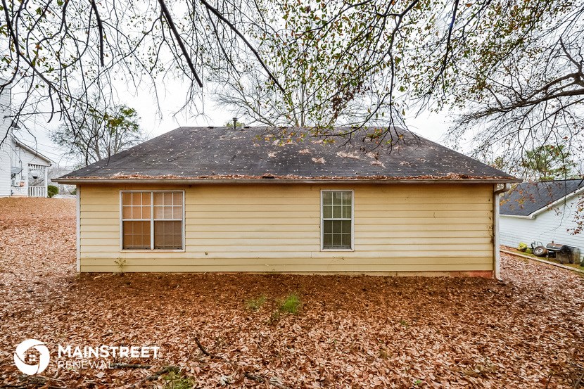 a small yellow house in the yard under a tree