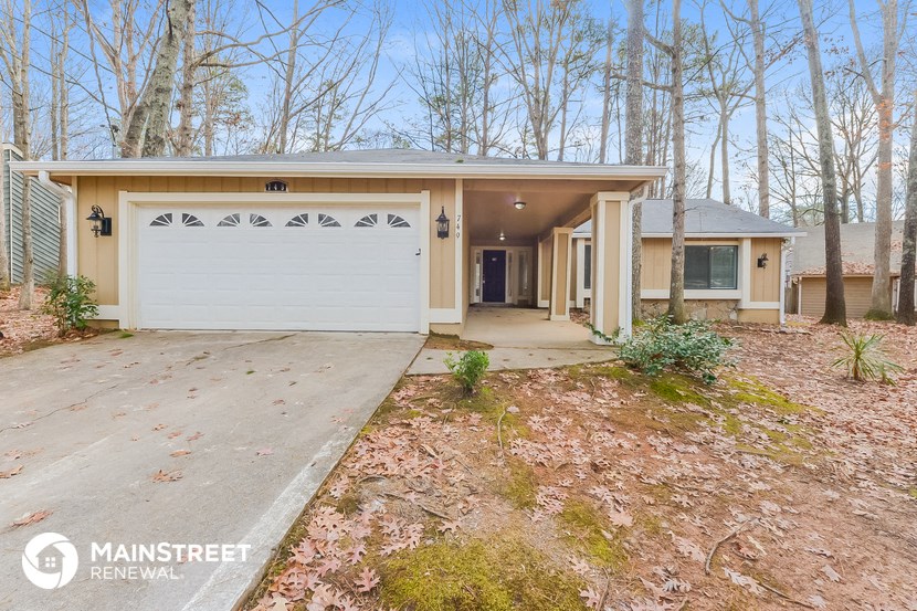 a home in the woods with a white garage door
